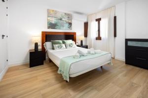 sypialnia z dużym łóżkiem i telewizorem w obiekcie Central and Spacious Apartment with Parking on-site w Maladze