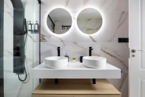 łazienka z dwoma umywalkami i dwoma lustrami w obiekcie Central and Spacious Apartment with Parking on-site w Maladze