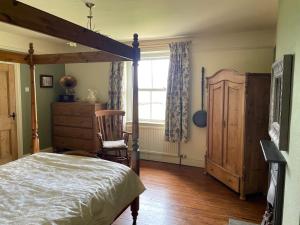 a bedroom with a bed and a chair and a window at Luxurious Granny House Bell Busk in Malhamdale in Skipton