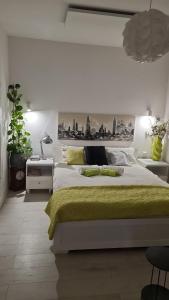 a white bedroom with a large bed with a yellow blanket at Przytulny apartament 2 in Żywiec