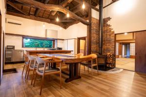 a kitchen with a table and chairs and a fireplace at 旧邸貸別荘 南壽庵 in Tateyama