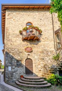 a stone building with a balcony and stairs on it at La Casa nel Borgo in San Felice del Benaco