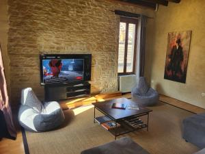 a living room with two chairs and a television at Le Chardonnay in Savigny-lès-Beaune