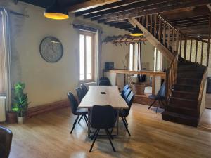 a dining room with a table and chairs and a staircase at Le Chardonnay in Savigny-lès-Beaune