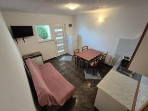 a small room with a table and a dining room at Apartmani Tamaris in Zubovići