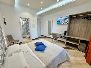a bedroom with a bed with blue pillows on it at La Maison Du Soleil Rooms in Agerola