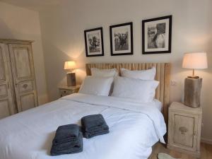 a bedroom with a white bed with two towels on it at VILLA ADOYA Chambre d'hôtes Aigues-Mortes intra muros au calme climatisation réversible PISCINE WIFI ascenseur PARKING gratuit in Aigues-Mortes