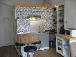 a small kitchen with a sink and a counter with stools at Type 2, Valenciennes centre, 40 m2 in Valenciennes