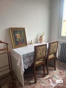 a dining room table with two chairs and a table with a white table cloth at stazione Lina house in Venice
