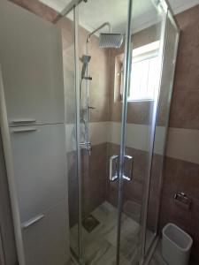 een douche met een glazen deur in een badkamer bij Anastasija in Merdari