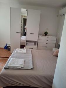 een slaapkamer met twee bedden en een grote spiegel bij Anastasija in Merdari