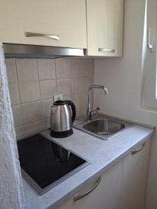 een keuken met een wastafel en een waterkoker bij Anastasija in Merdari