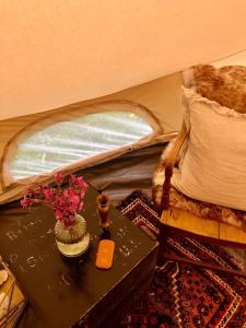 a table with a vase of flowers on it in a tent at Cool Cow Glamping in Hope-Cove