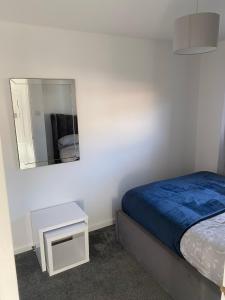 a small bedroom with a bed and a mirror at Millview house in Airdrie +4 photos