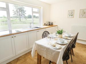 a kitchen with a table with chairs and a sink at Lake View Cottage in Alford