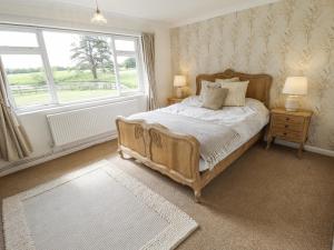 a bedroom with a large bed and a window at Lake View Cottage in Alford