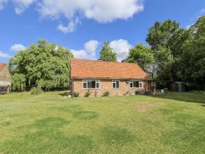 a small brick house with a large grass yard at Lake View Cottage in Alford