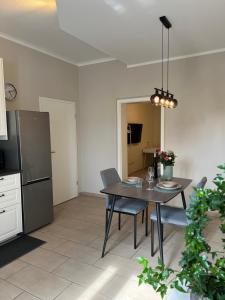 eine Küche mit einem Tisch mit Stühlen und einem Kühlschrank in der Unterkunft Ruhrperle Apartment 1 Essen in Essen