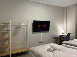 ein Schlafzimmer mit einem Bett und einem Fernseher an der Wand in der Unterkunft Ruhrperle Apartment 1 Essen in Essen