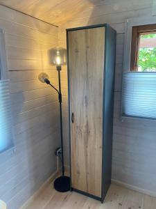a room with a door and a lamp next to a wall at Ferienhaus am See Wutzsee mit direktem Seezugang in Lindow