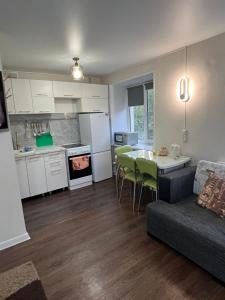 a kitchen and living room with a couch and a table at Квартира на Протозанова 39 in Ustʼ-Kamenogorsk