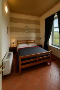 a bedroom with a bed and a window at Locanda Del Barbaresco in Alba