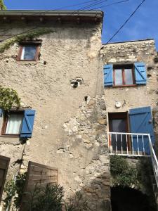 an old building with blue shutters on it at Charmante petite maison in Aouste-sur-Sye
