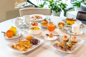 a table with plates of breakfast food on it at Enjoy Garda Hotel in Peschiera del Garda