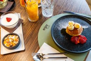 a table with a plate of pancakes and strawberries at Enjoy Garda Hotel in Peschiera del Garda +37 photos