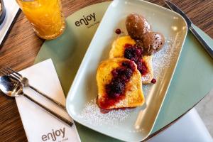 a plate of food with pancakes and berries on a table at Enjoy Garda Hotel in Peschiera del Garda