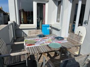 TréffiagatにあるHébergement la plage à piedの木製テーブル、バルコニー(椅子2脚付)