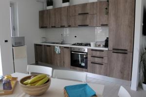 a kitchen with wooden cabinets and a bowl of bananas on a table at Magnolia in Francavilla al Mare +82 photos