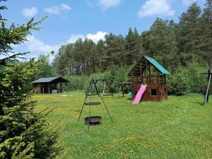 a playground with a play structure and a swing at Domki Sosnowa dolina We wielu in Wiele