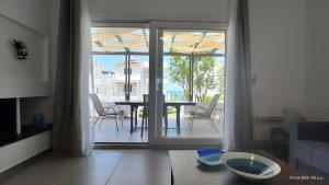a living room with a view of a table and chairs at Seafront Villa Christina in Kanatádhika
