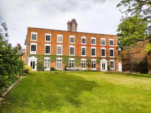 a large brick building with a large yard at The Old House Apartment in Shrewsbury