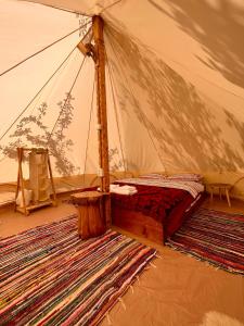 a bed in a tent with a rug in a room at Wild Glamping Cornereva in Cornereva