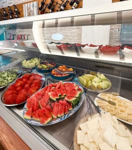 a display case with many plates of fruits and vegetables at Kompleksi Muja in Velipojë