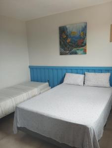deux lits dans une chambre avec un tableau au mur dans l'établissement Casa em Buzios, à Búzios