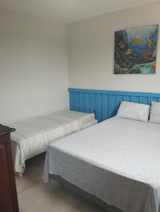 deux lits dans une chambre avec un tableau au mur dans l'établissement Casa em Buzios, à Búzios 26 autres photos