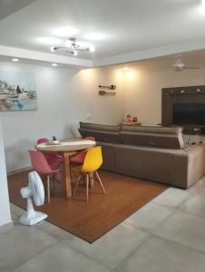un salon avec un canapé, une table et des chaises dans l'établissement Casa em Buzios, à Búzios