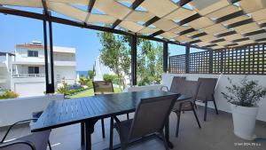 a patio with a table and chairs on a balcony at Seafront Villa Christina in Kanatádhika