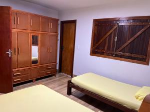a bedroom with two beds and wooden cabinets at Chácara Recanto Ribeiro in Pirenópolis