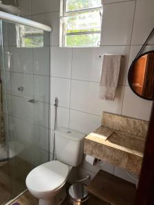 a bathroom with a toilet and a glass shower at Chácara Recanto Ribeiro in Pirenópolis