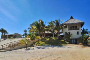 a house on the beach with palm trees at Rancho De Costa by Cabo Villas in La Paz