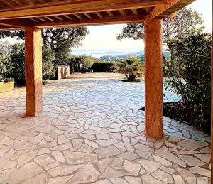 a stone patio with a wooden pergola at Loucasa Location les Issambres in Les Issambres +21 photos