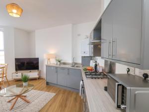 a kitchen with stainless steel appliances and a table at Glenholme Apartment 1 in Redcar