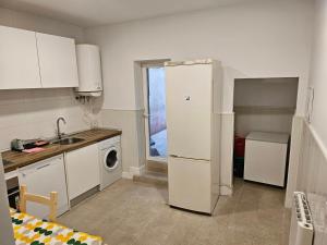 Una cocina con un refrigerador blanco y un fregadero. en Hogar en Lavapies 11, en Madrid
