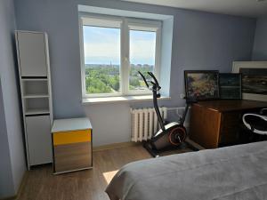 a bedroom with a bed and a desk and a window at Apartaments Kaunas in Kaunas