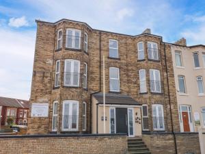 a large brick building with white windows and doors at Glenholme Apartment 3 in Redcar