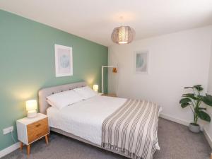 a bedroom with a bed and a green wall at Glenholme Apartment 3 in Redcar